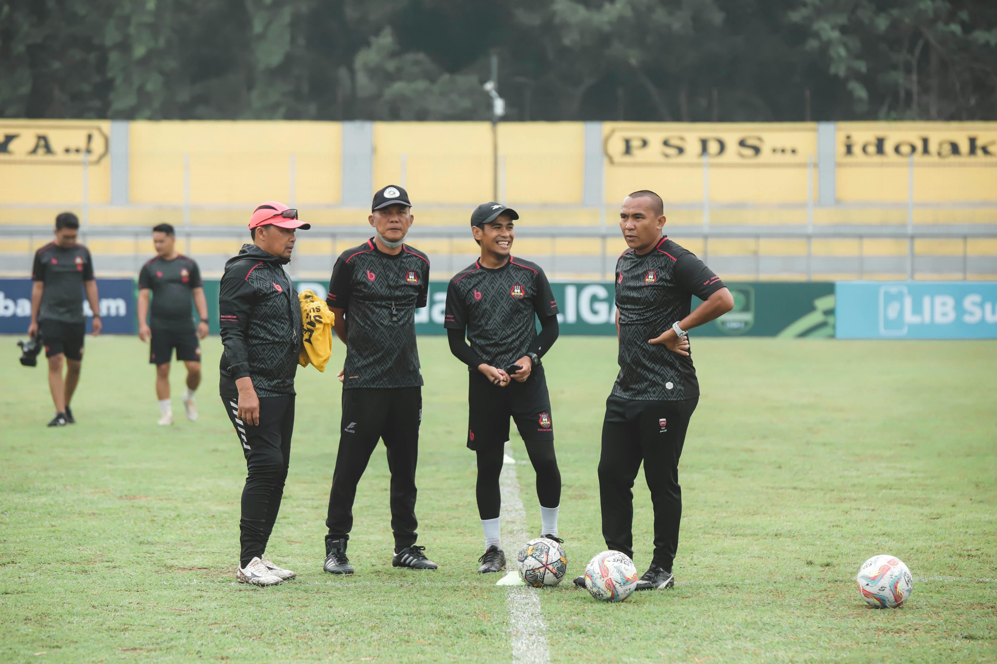Soccer players on a field discussing tactics