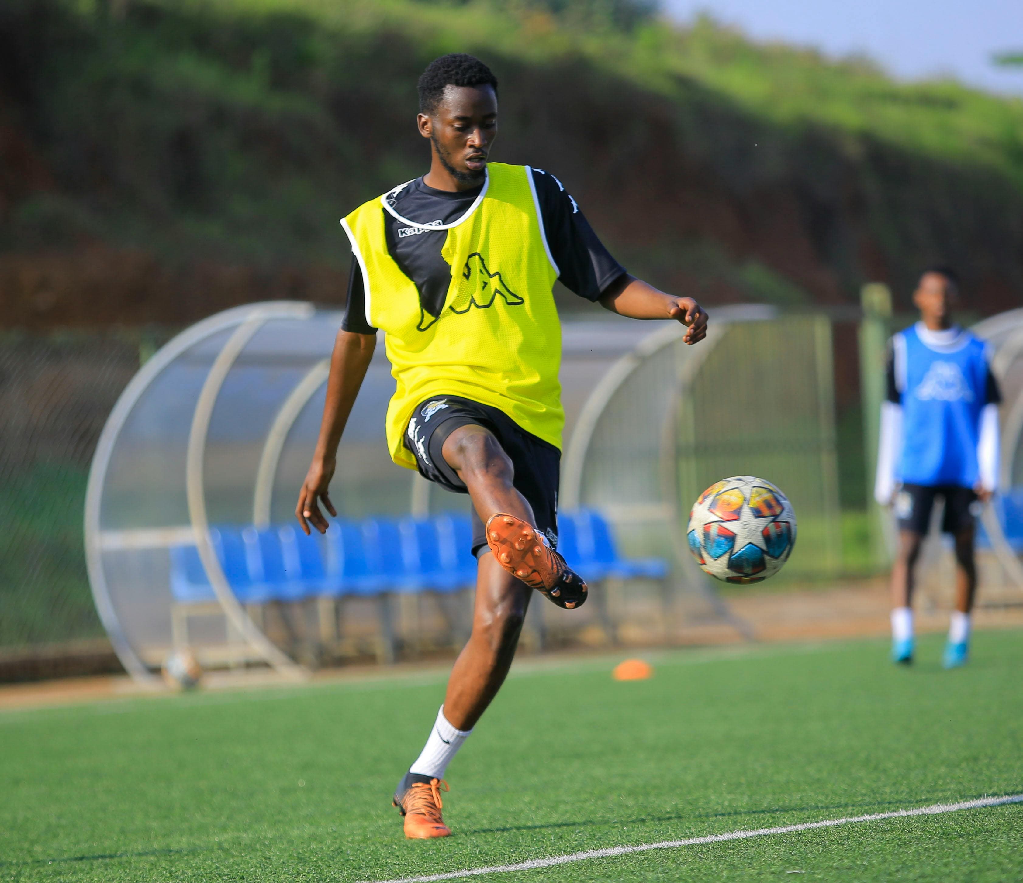 Player in yellow training vest with a soccer ball